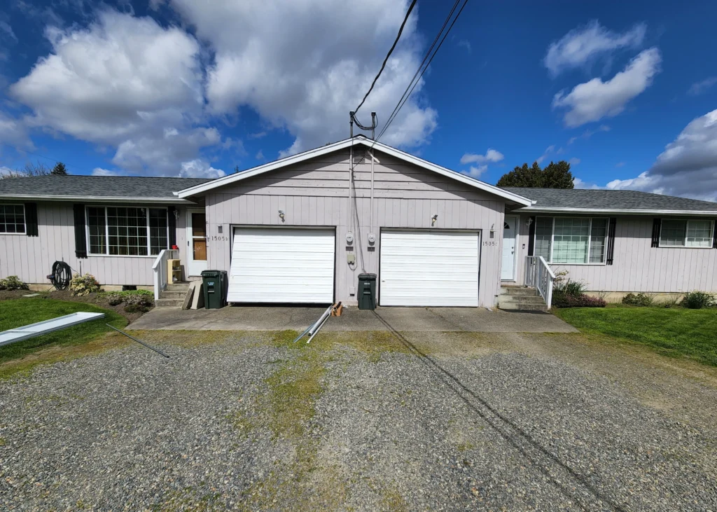 Residential duplex with garages and clouds